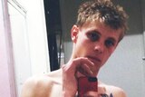 Alex Robert Smart takes a selfie in a mirror with no shirt on.