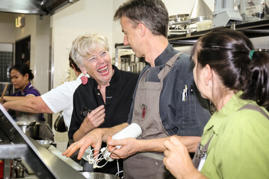 Maggie Beer laughing with cook in kitchen
