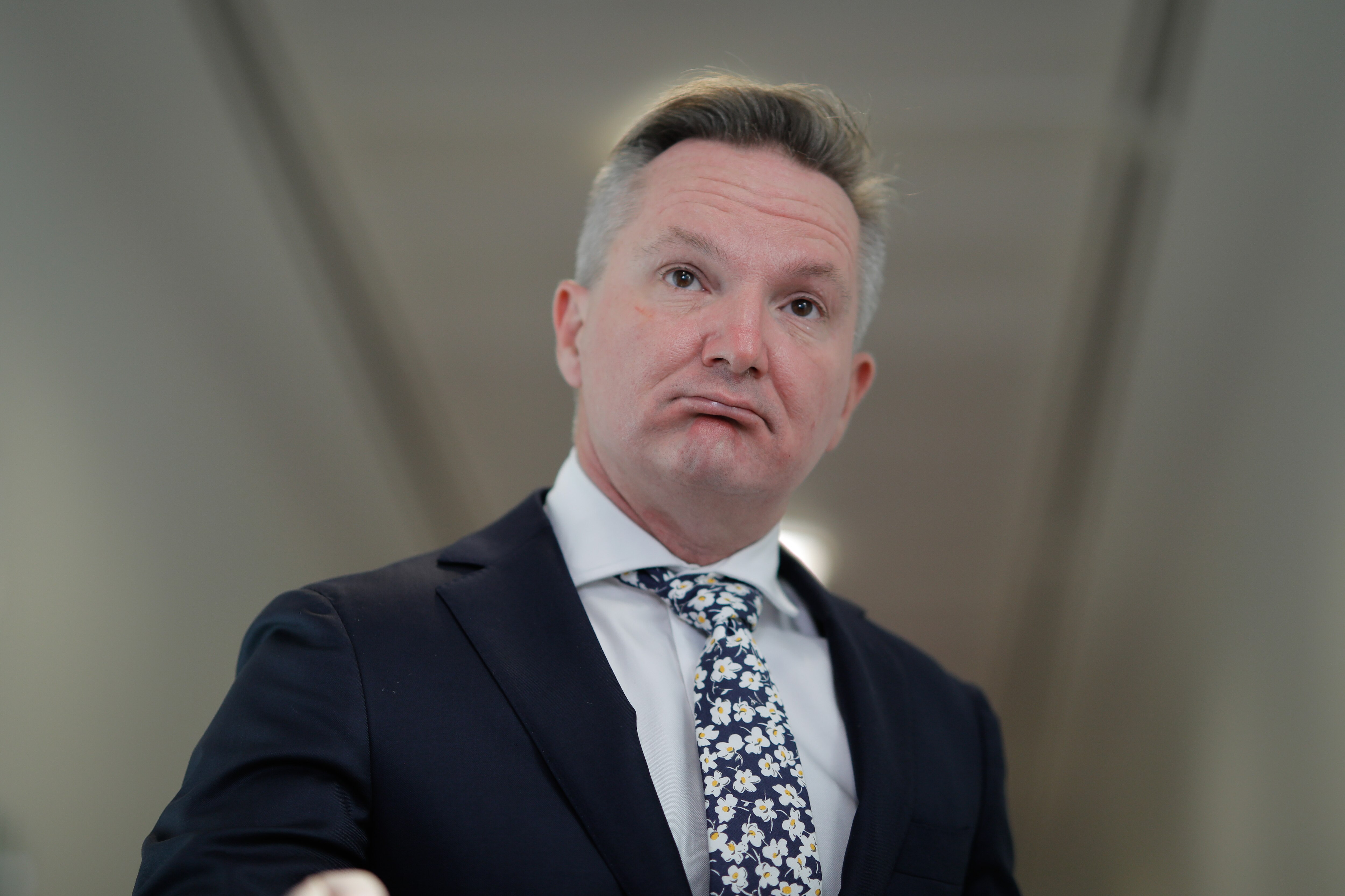 A close up image of a man wearing a suit and tie.