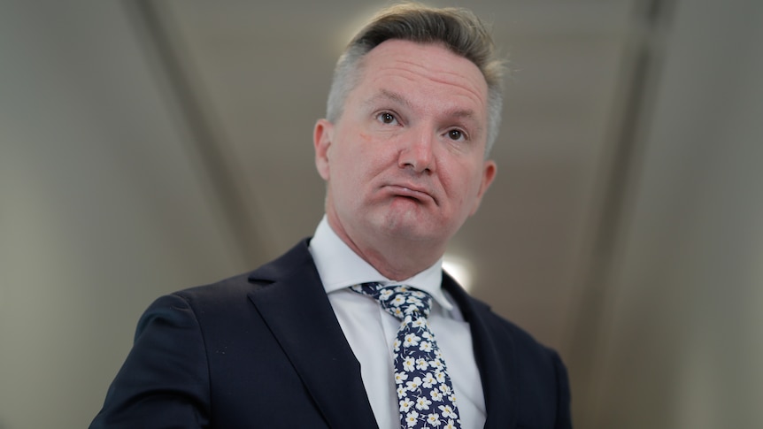 A close up image of a man wearing a suit and tie.