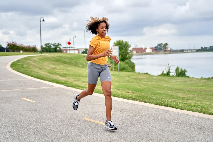 A woman runs on a footpath.