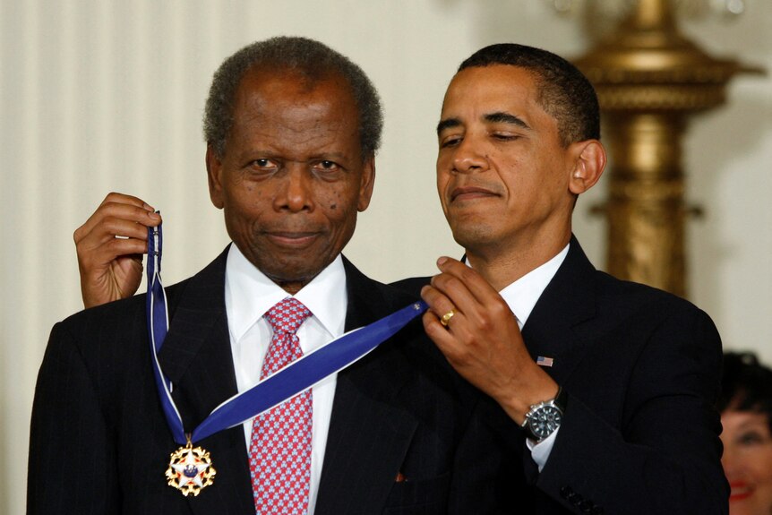 US President Barack Obama presents the Medal of Freedom to veteran actor Sidney Poitier.
