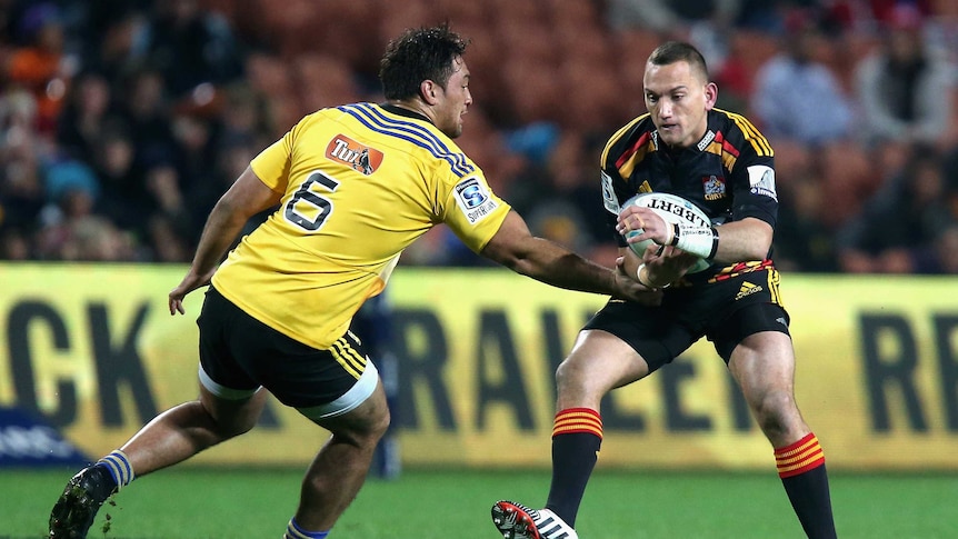 Aaron Cruden gets by the Hurricanes defence