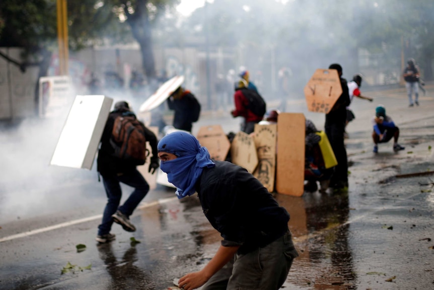 Demonstrators hide behind shields during riots in the street.