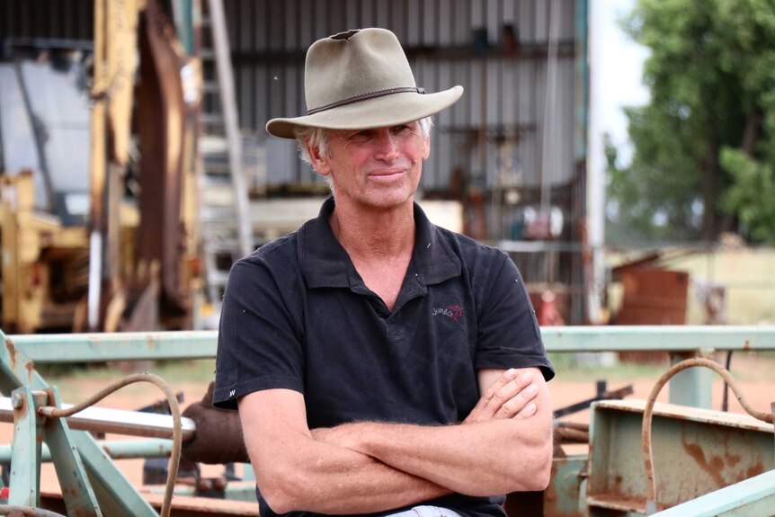 A man in a black t-shift and an Akubra.
