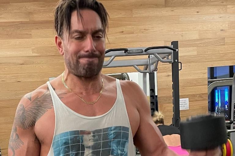 Duran Raman in the gym in a tank shirt and fringe over his face.