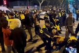 Police officers detain people during a protest against coronavirus disease curbs.