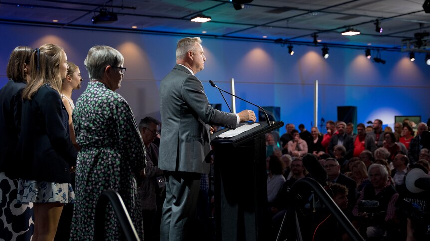 Tasmanian Premier Jeremy Rockliff stands at the podium in the tally room in Hobart in front of his family