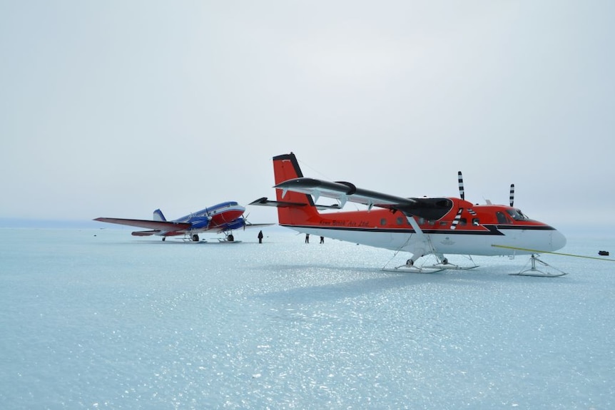 Two planes sitting on the ice