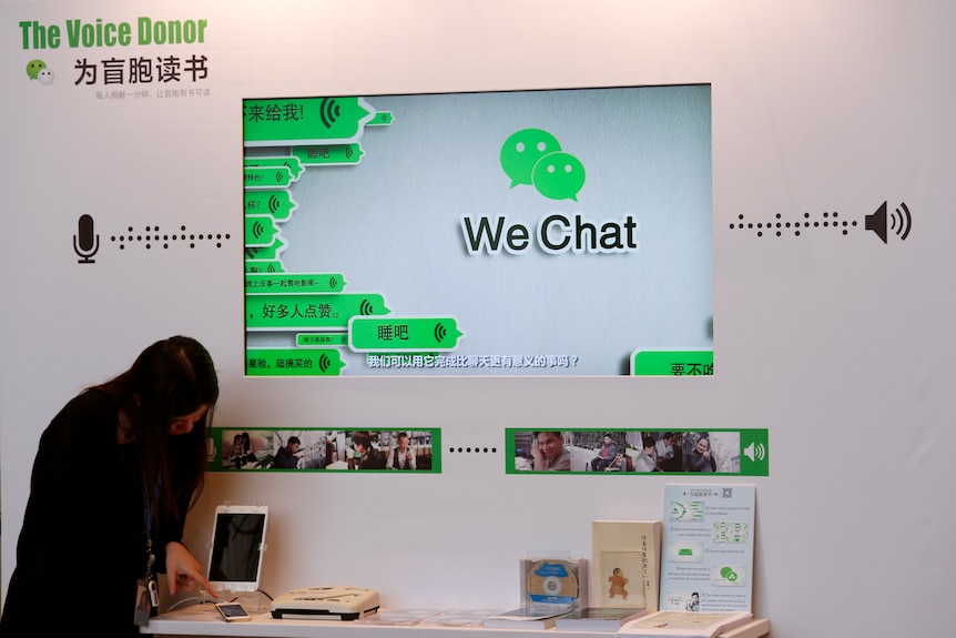 Una mujer prueba un servicio de lectura de libros respaldado por WeChat. 