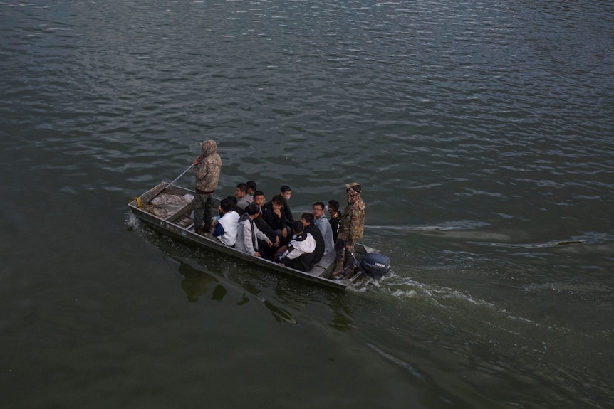 Migrants from China ride in a motorised boat