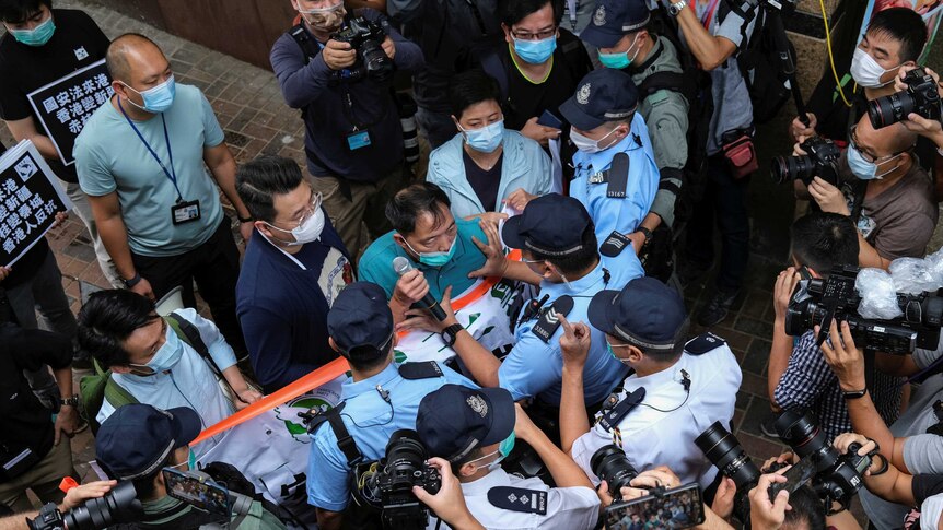 Pro-democracy lawmaker Wu Chi-wai scuffles with police.