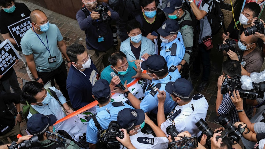 Pro-democracy lawmaker Wu Chi-wai scuffles with police.