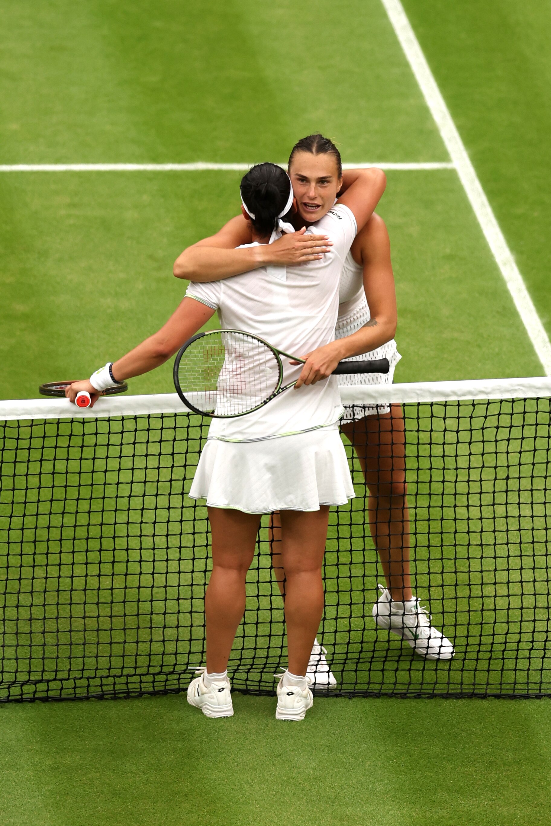 Two women tennis player hugging each other after match. 