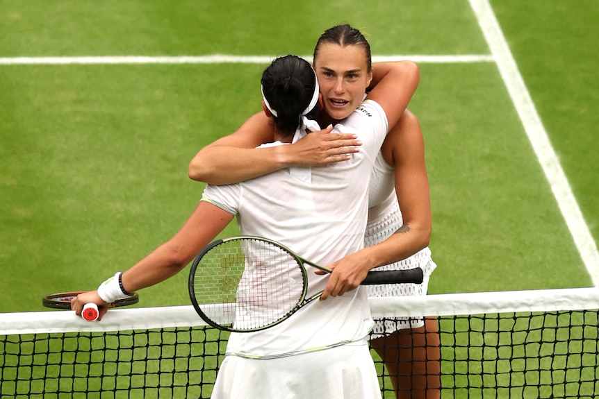 Two women tennis player hugging each other after match. 