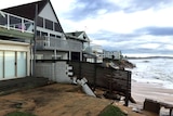 A fence falling onto the beach.