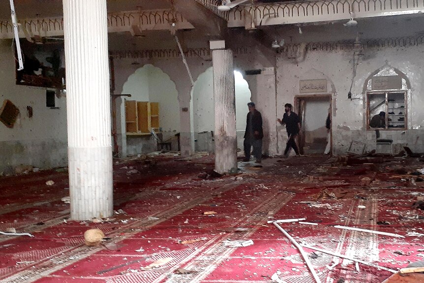 Des volontaires examinent le site de l'explosion à l'intérieur d'une mosquée chiite.