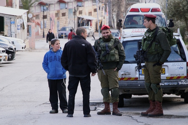 Civilians talk to two IDF soldiers
