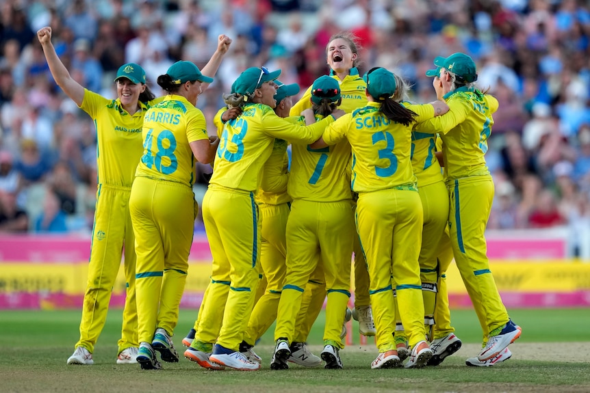 Australian cricketers embrace after the Commonwealth Games gold medal T20 match against India.