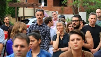 People stand around at a house auction.