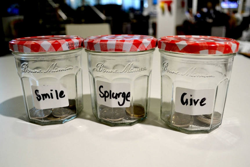 Three jams jars, each with a label reading "smile", "splurge" or "give.
