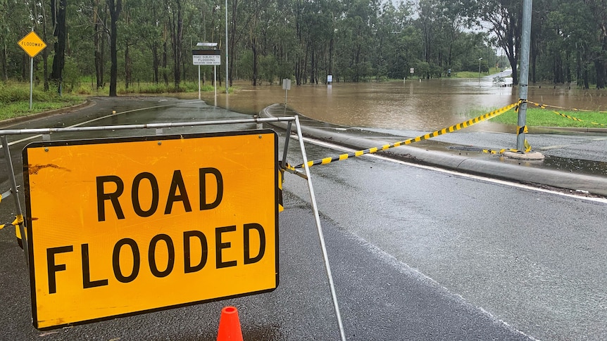 Roads closed sign due to flooding at Jimboomba.