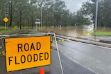 Roads closed sign due to flooding at Jimboomba.