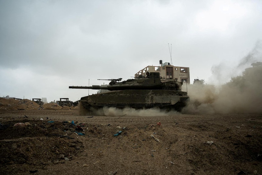 An Israeli soldier rides in a tank, amid the ongoing ground operation of the Israeli army in Gaza.