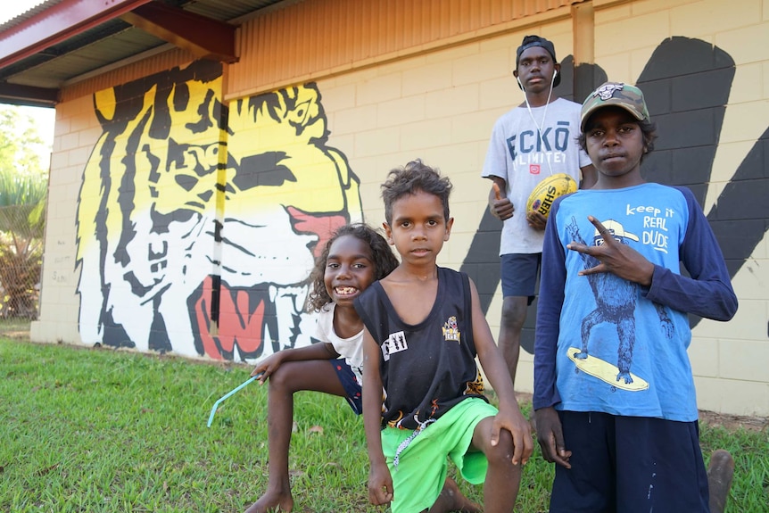 A group of children in Pirlangimpi hold an AFL ball.