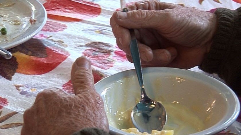 Elderly homeless man eats dessert at Mercy Arms day care centre.
