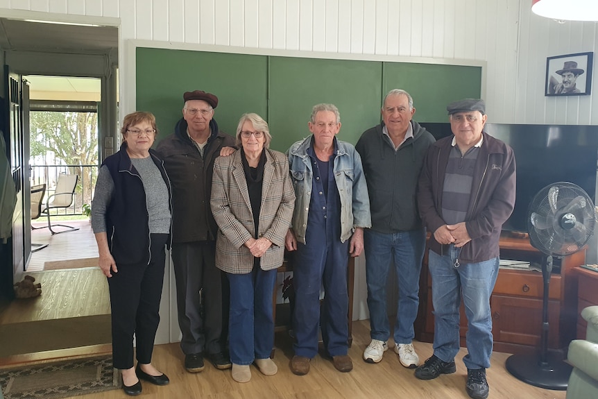 People stand in front of a blackboard