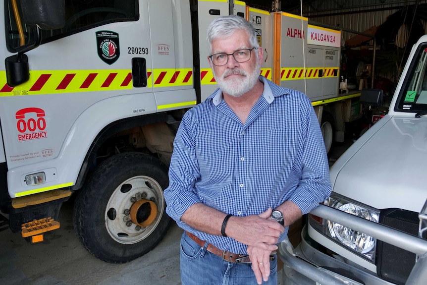 A man standing in front of a fire truck.