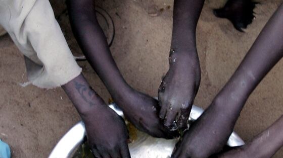 Displaced Sudanese children eat at the Sakali Displaced Persons camp.