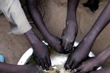 Displaced Sudanese children eat at the Sakali Displaced Persons camp.