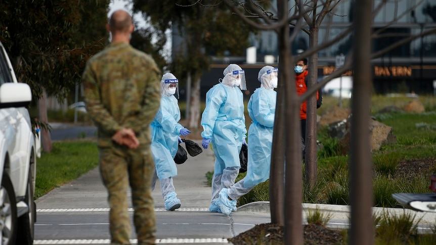 Health workers in full personal protective equipment walk into the Epping Gardens aged care home.