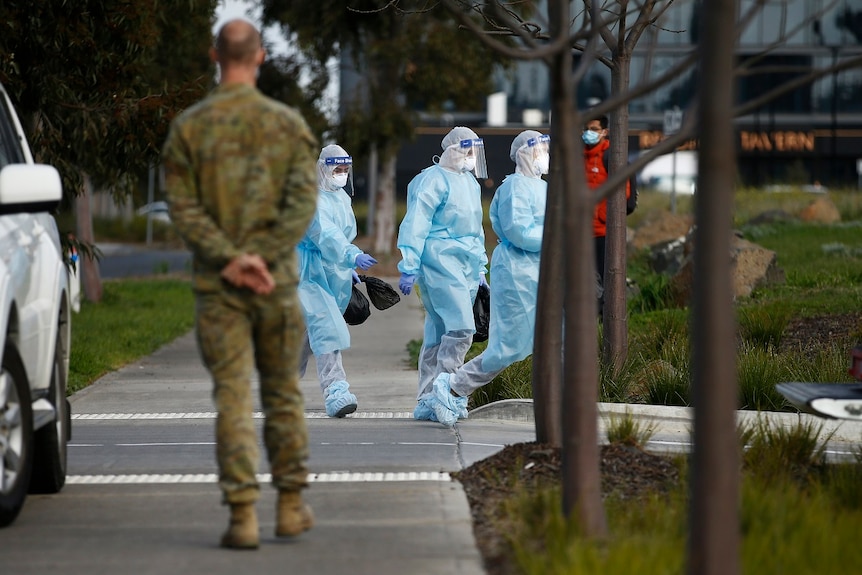 Health workers in full personal protective equipment walk into the Epping Gardens aged care home.