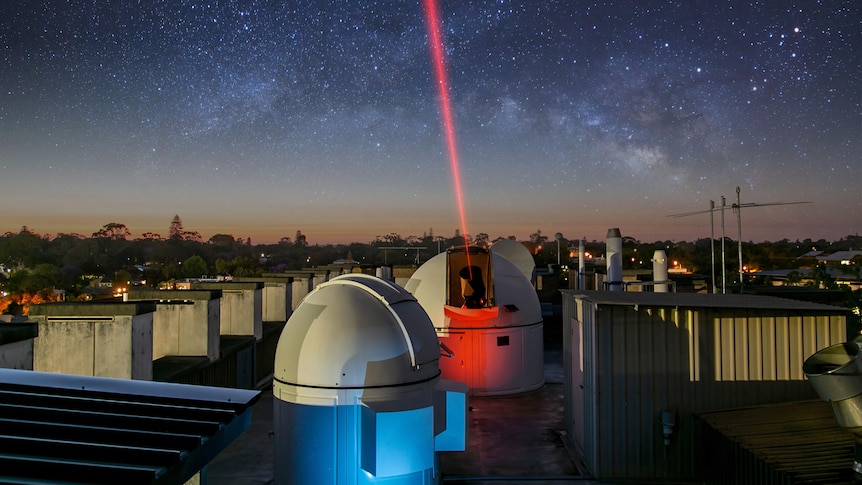Telescope shooting a red laser into the sky
