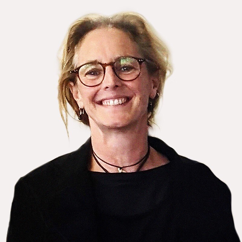 A headshot of a woman, Kate Munro, smiling at the camera. She has blonde hair and is wearing glasses