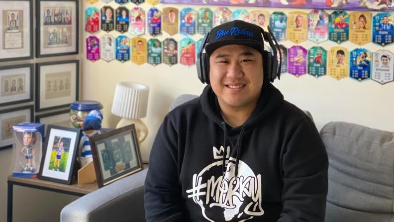 A young man wearing headphones and a hoody