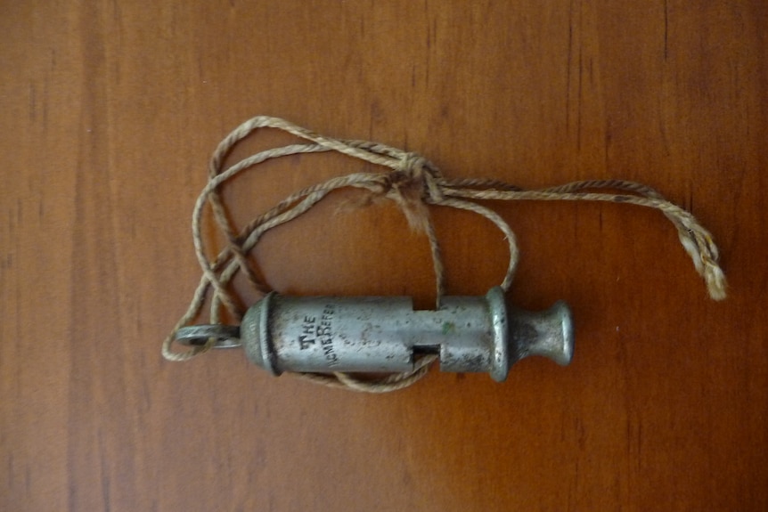Old metal whistle on a string, used in Antarctica by young Clarence Hare in 1902.