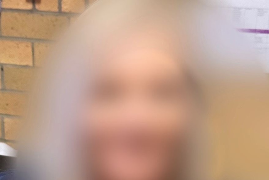 A close up portrait of a woman, blurred to protest her identity.