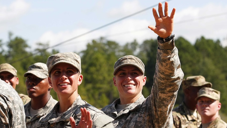 Two women in US Army uniforms wave
