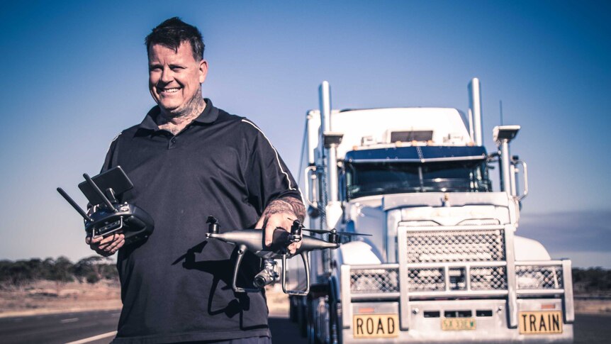 Truck driver holding remote-controlled drone