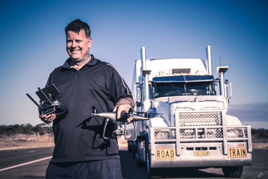 Truck driver holding remote-controlled drone