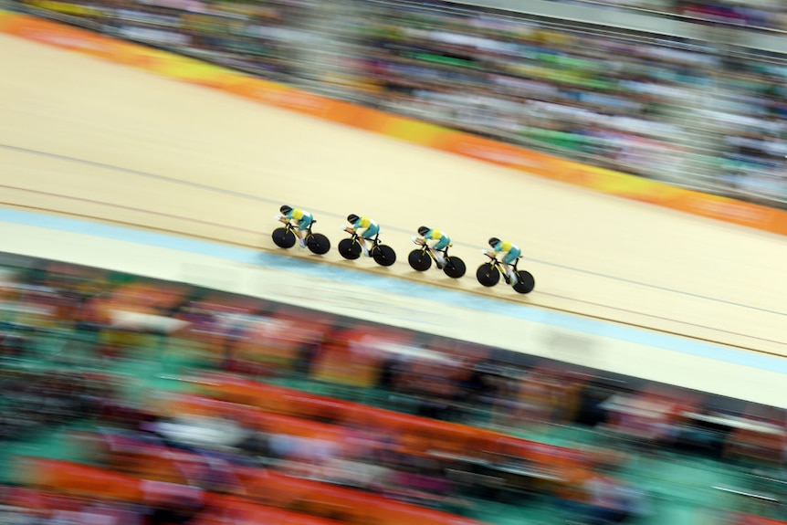 The Australian Cycling team riding among a blurry crowd in Rio.