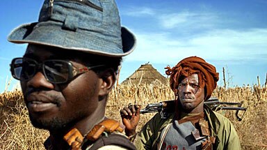On patrol: Sudan Liberation Army rebels walk through a village in Darfur.