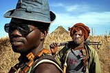 On patrol: Sudan Liberation Army rebels walk through a village in Darfur.