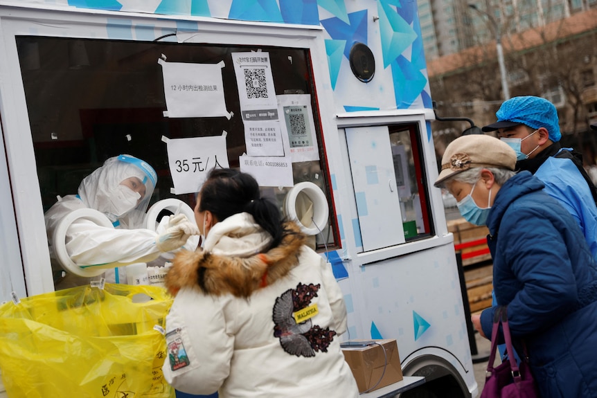 A woman gets tested for the coronavirus disease at a mobile nucleic acid testing site on a street in Beijing.