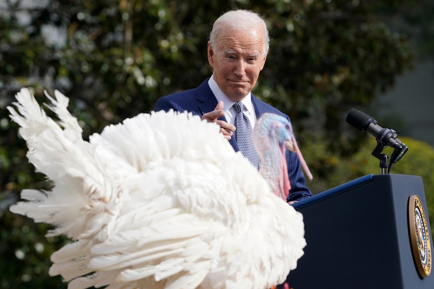 Joe Biden points to a massive turkey from his presidential lectern 