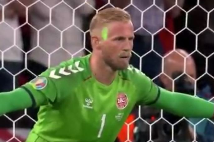 Kasper Schmeichel looks focussed despite the green light flashing on his face